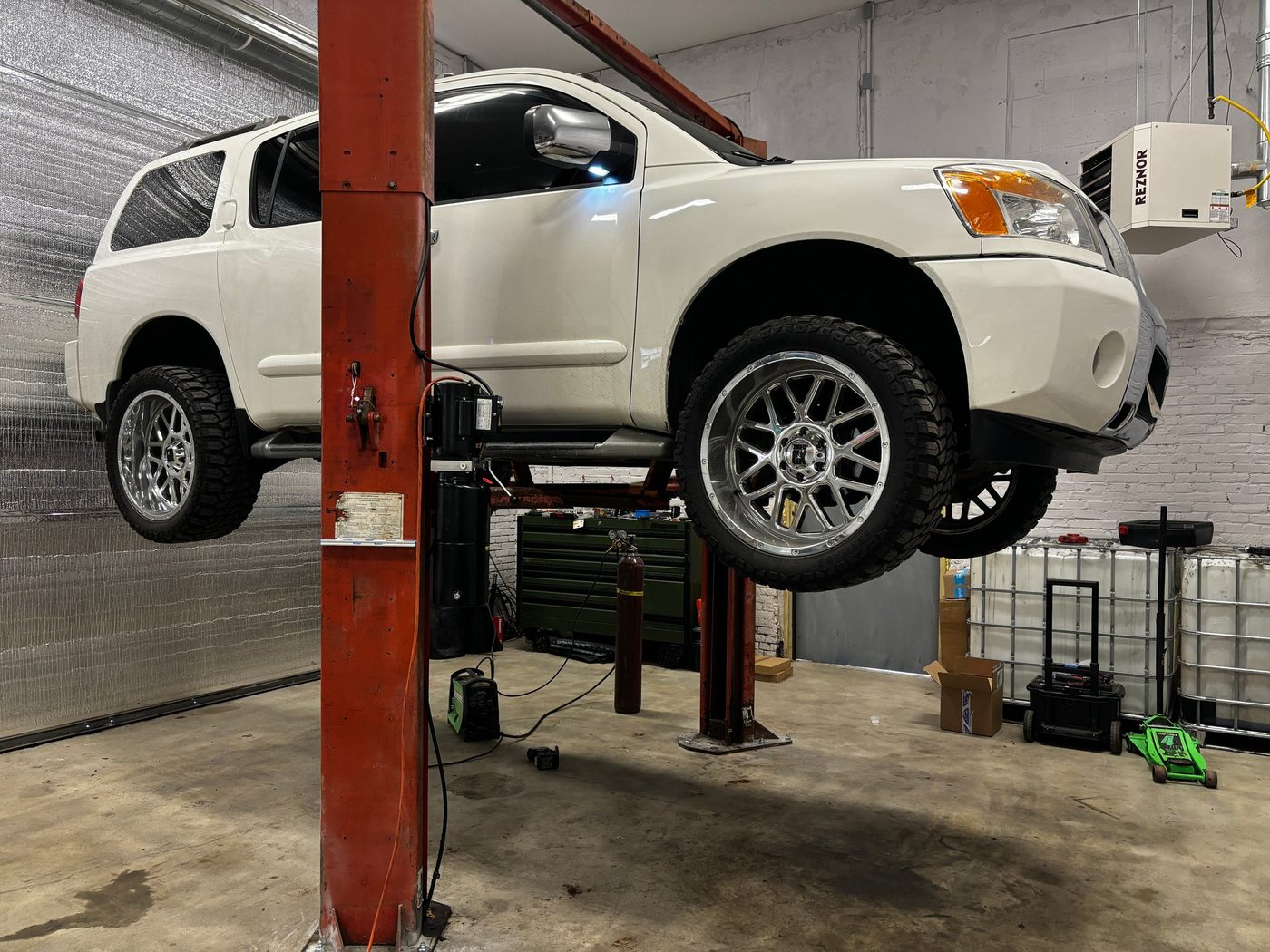 A white SUV on the lift
